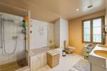 This bathroom features a spacious shower and a separate bathtub, perfect for relaxation.