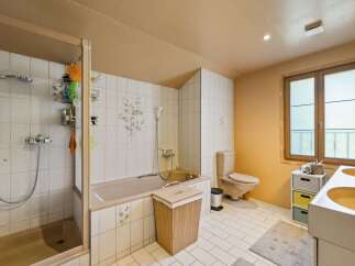 This bathroom features a spacious shower and a separate bathtub, perfect for relaxation.