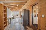 Discover this spacious room with a rustic wooden ceiling and walls, perfect for a workshop or storage area.