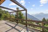 Experience breathtaking mountain vistas from this stunning wooden deck, perfect for enjoying the serene alpine landscape.