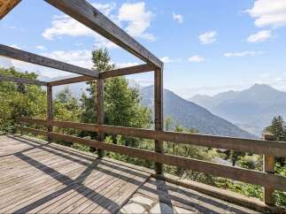 Experience breathtaking mountain vistas from this stunning wooden deck, perfect for enjoying the serene alpine landscape.