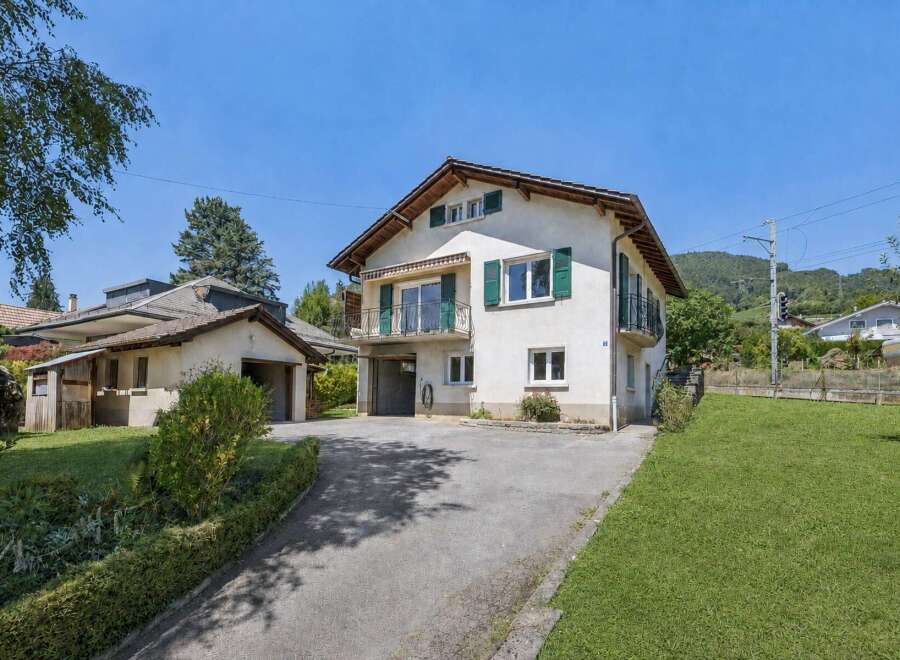 Discover this charming property featuring a spacious main house with multiple balconies and green shutters, complemented by an adjacent garage and a separate workshop area.
