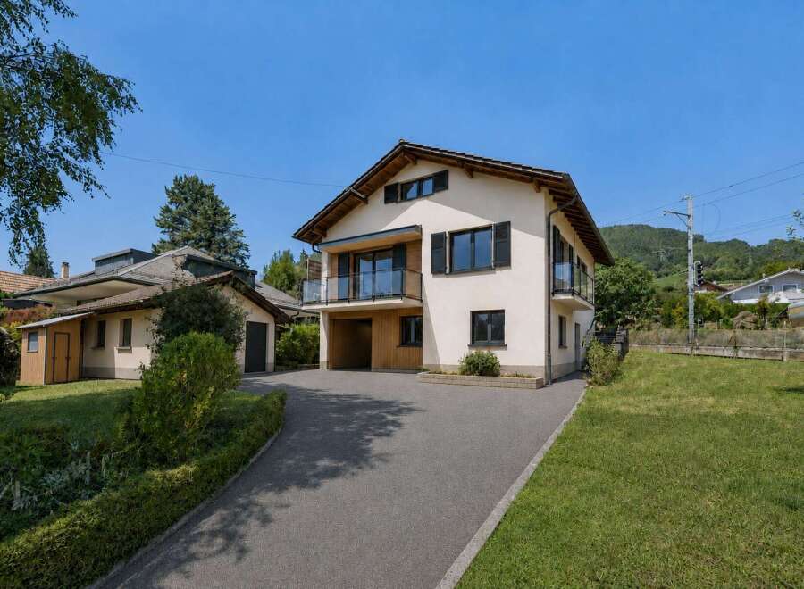Discover this modern two-story home featuring a sleek stucco exterior and a prominent wooden-clad entrance.
