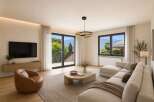 Experience modern living in this stunning living room, featuring a sleek sectional sofa and a stylish leather armchair.