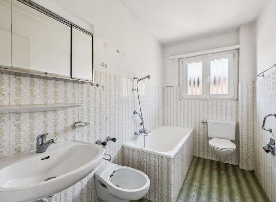 This classic bathroom features a functional layout with a bathtub, sink, and toilet.