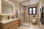 Experience modern luxury in this stunning bathroom featuring a sleek vanity with ample storage, a spacious walk-in shower with a rainfall showerhead, and a wall-mounted toilet.