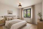 Experience serene living in this beautifully appointed bedroom, featuring a plush king-sized bed adorned with soft, neutral linens and accent pillows.