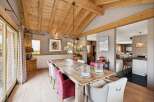 Experience rustic elegance in this spacious dining room, featuring a grand wooden table perfect for gatherings.