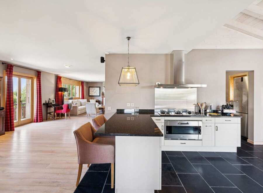 Experience modern living in this open-concept home, featuring a sleek kitchen with a granite island and stainless steel appliances.