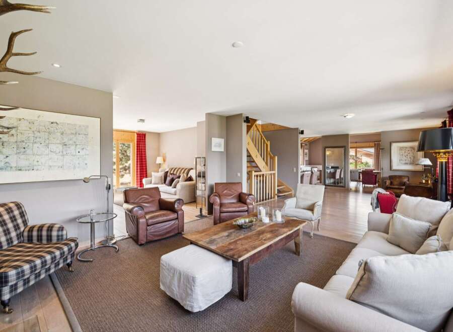 Experience rustic charm and sophisticated comfort in this spacious living area, featuring plush seating arrangements perfect for relaxation and entertaining.