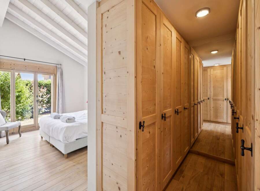 Experience rustic charm in this inviting bedroom featuring a comfortable bed and a cozy armchair, perfect for relaxation.