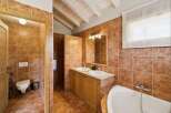 This charming bathroom features rustic terracotta tiles throughout, creating a warm and inviting atmosphere.