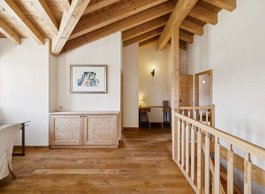 Experience rustic charm in this spacious hallway featuring exposed wooden beams and a warm, inviting atmosphere.