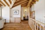 Experience rustic charm in this spacious hallway featuring exposed wooden beams and a warm, inviting atmosphere.