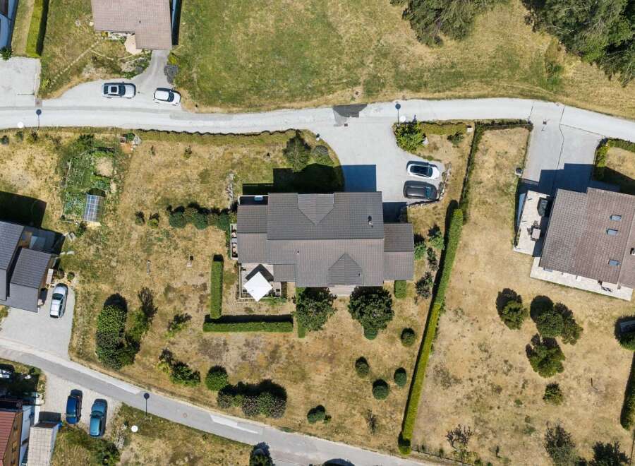 Discover this stunning property from an aerial perspective, showcasing a beautifully maintained home with a spacious roof and an inviting outdoor patio area.