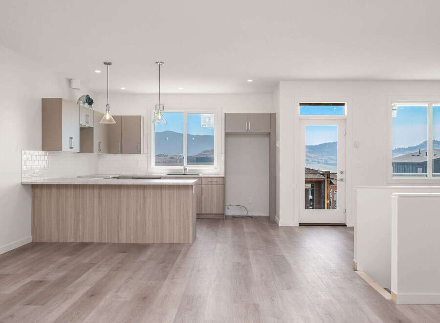 Experience modern living in this spacious open-concept kitchen and living area, featuring sleek cabinetry and a large island perfect for entertaining.
