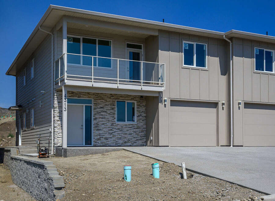 Discover modern living in this stunning townhouse featuring a sleek facade with stone accents and a spacious balcony.