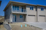 Discover modern living in this stunning townhouse featuring a sleek facade with stone accents and a spacious balcony.