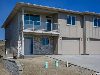 Discover modern living in this stunning townhouse featuring a sleek facade with stone accents and a spacious balcony.