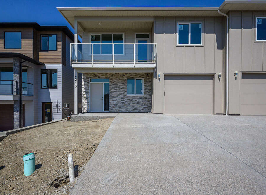 Discover modern living in this stunning townhouse featuring a sleek facade with stone accents and a spacious balcony.
