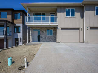 Discover modern living in this stunning townhouse featuring a sleek facade with stone accents and a spacious balcony.