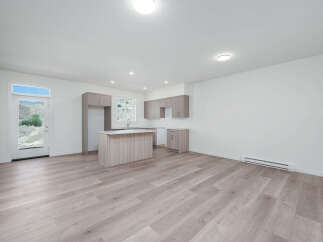 Discover modern living in this bright and airy open-concept space, featuring a sleek kitchen with ample cabinet storage and a central island perfect for meal prep and casual dining.