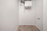 This laundry room is ready for your appliances, featuring a modern ventilation system for optimal air quality.