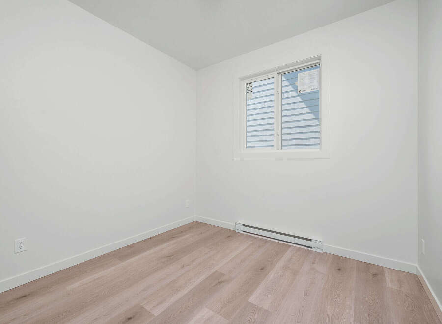 Discover modern living in this bright and airy room, featuring a large window that floods the space with natural light.