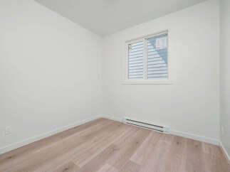 Discover modern living in this bright and airy room, featuring a large window that floods the space with natural light.