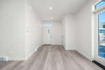 Step into this bright and airy entryway, featuring modern light wood flooring and crisp white walls.