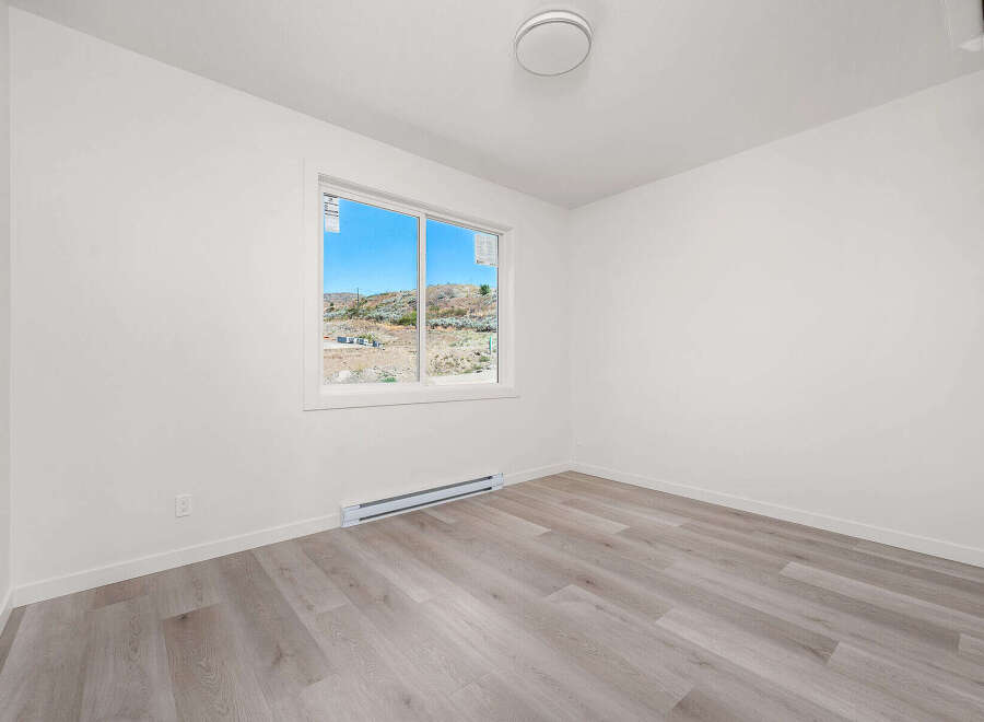 Discover this bright and airy bedroom, featuring a large window that floods the space with natural light.