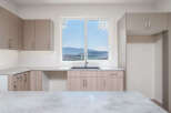 Experience modern living in this stunning kitchen featuring sleek cabinetry and a large window with breathtaking mountain views.