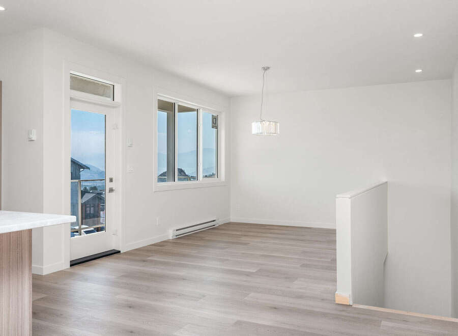 Experience modern living in this bright and airy dining area, featuring a stunning crystal chandelier and large windows that offer breathtaking mountain views.