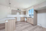 Discover this modern kitchen featuring sleek, dual-toned cabinetry and a spacious island with a granite countertop.