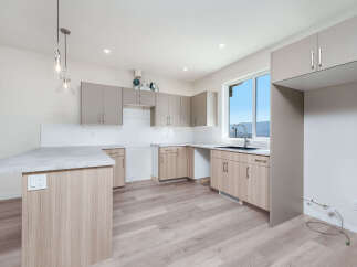 Discover this modern kitchen featuring sleek, dual-toned cabinetry and a spacious island with a granite countertop.