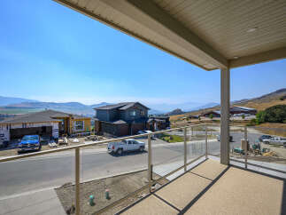 Enjoy breathtaking panoramic views from this stunning property, featuring a modern home under construction with a spacious balcony.