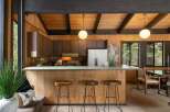 Experience rustic charm in this kitchen featuring warm wood paneling and a spacious breakfast bar perfect for casual dining.