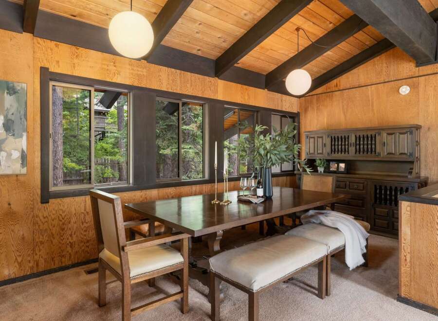 This dining room features a rustic charm with its wood-paneled walls and beamed ceiling.
