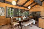 This dining room features a rustic charm with its wood-paneled walls and beamed ceiling.