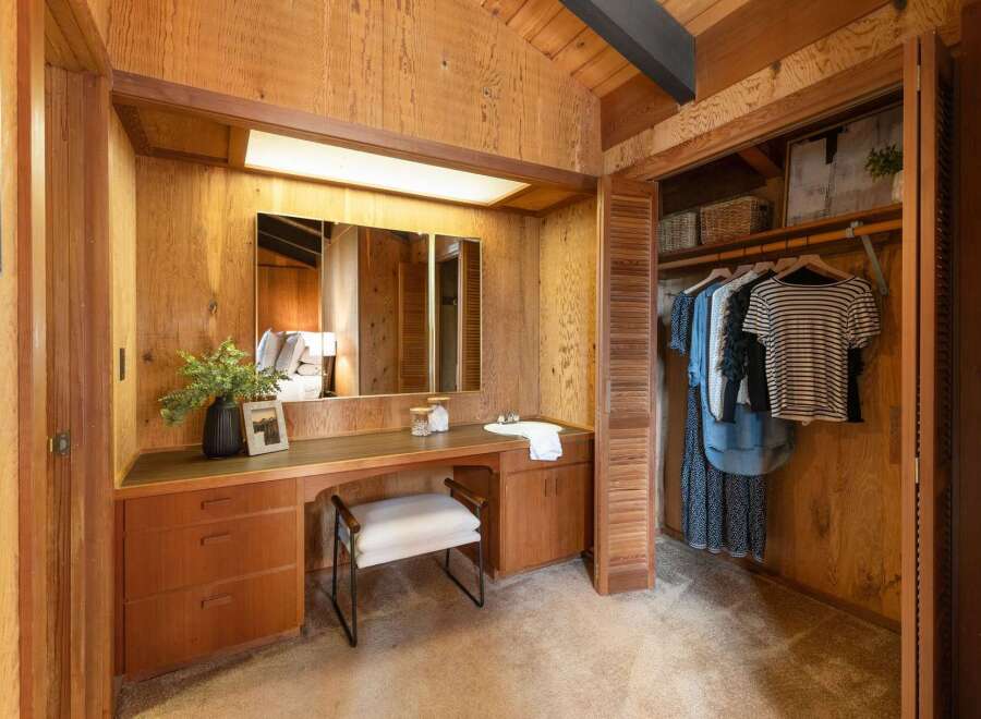 Discover this charming bedroom featuring a built-in vanity with ample storage and a large mirror, perfect for your morning routine.