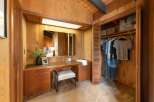 Discover this charming bedroom featuring a built-in vanity with ample storage and a large mirror, perfect for your morning routine.