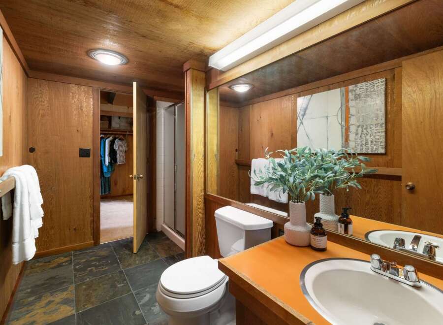 This rustic bathroom features warm wood paneling throughout, creating a cozy and natural ambiance.