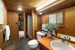This rustic bathroom features warm wood paneling throughout, creating a cozy and natural ambiance.