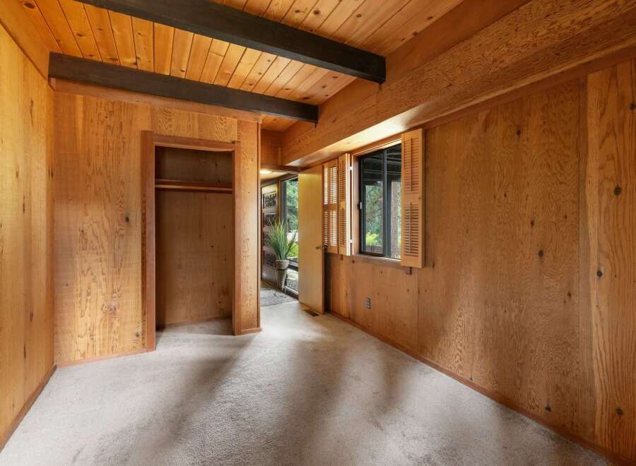 Step into a charming room featuring warm wood paneling and exposed beams, creating a cozy and rustic ambiance.