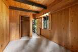 Step into a charming room featuring warm wood paneling and exposed beams, creating a cozy and rustic ambiance.