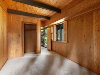 Step into a charming room featuring warm wood paneling and exposed beams, creating a cozy and rustic ambiance.