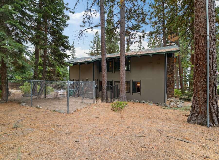 Discover this charming property nestled among tall pine trees, offering a private fenced yard perfect for pets or outdoor activities.