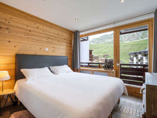 Experience mountain living in this charming bedroom featuring a cozy wooden accent wall and a plush king-sized bed.