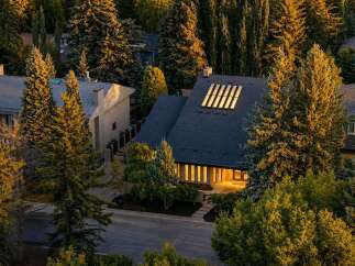 Nestled amidst mature trees, this stunning residence offers a unique architectural design with a striking roofline and abundant natural light.