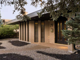 Discover this stunning modern home featuring a striking brick facade and a sleek, dark-toned roofline.